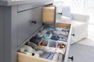 modern,open,chest,of,drawers,with,baby,clothes,and,accessories